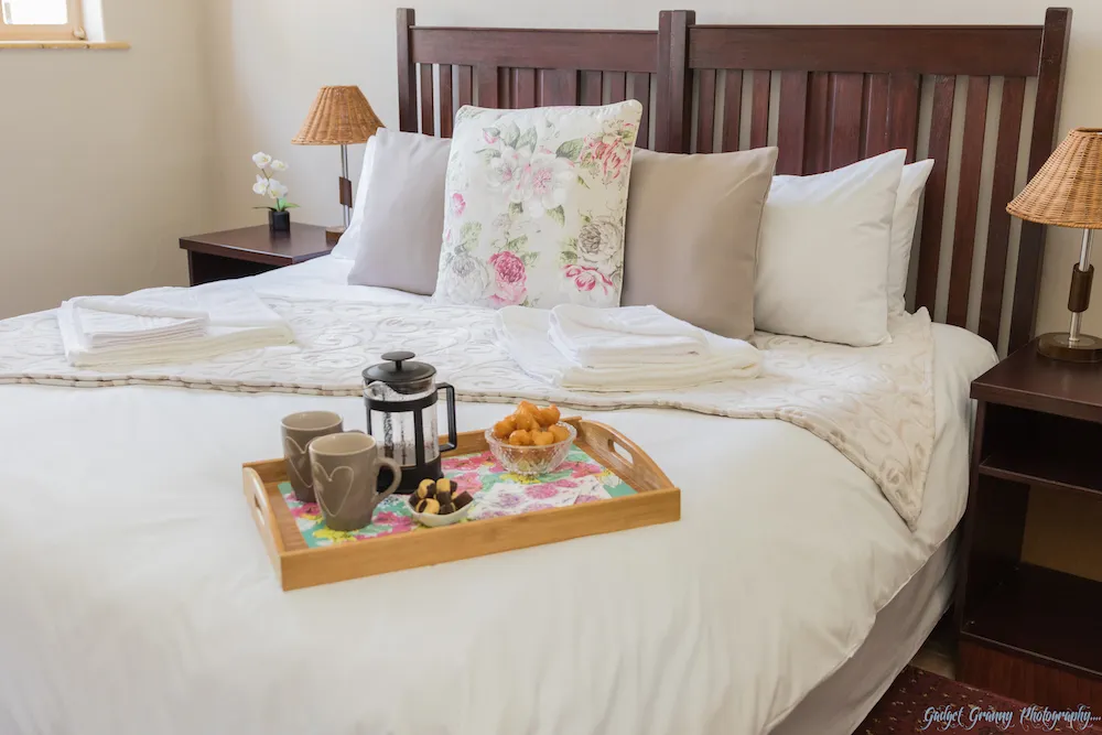Breakfast tray on a bed in a cozy bedroom with floral pillows