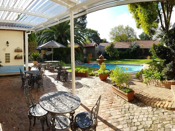 Outdoor patio with seating pool and garden under a pergola