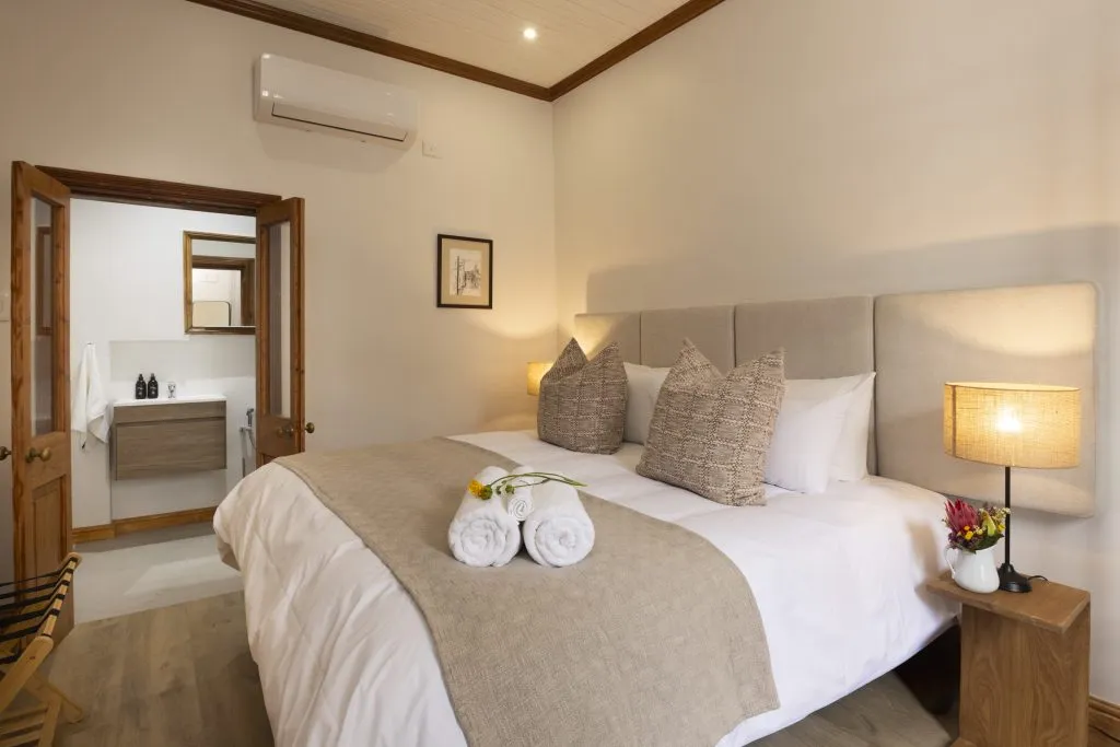 Cozy bedroom with a neatly made bed and an open door to a bathroom