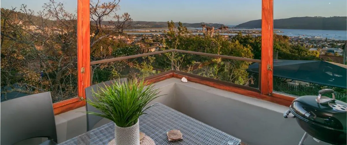 Balcony with table plant and city view through large windows