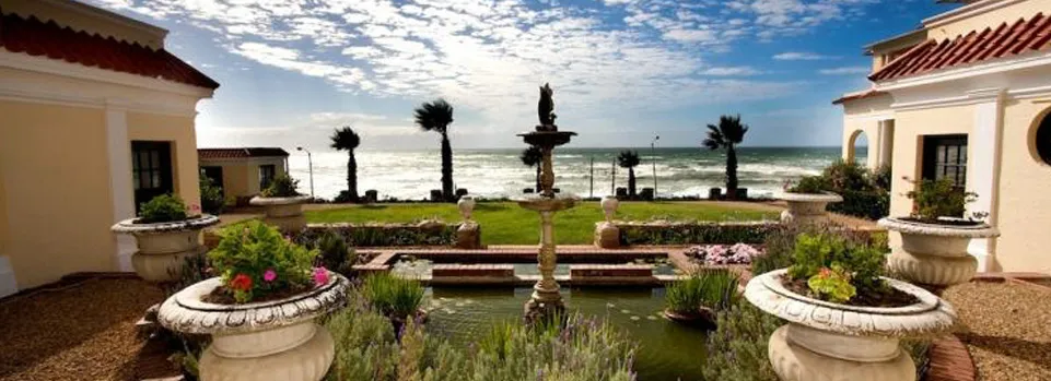 Mediterraneanstyle courtyard with fountain palm trees and ocean view