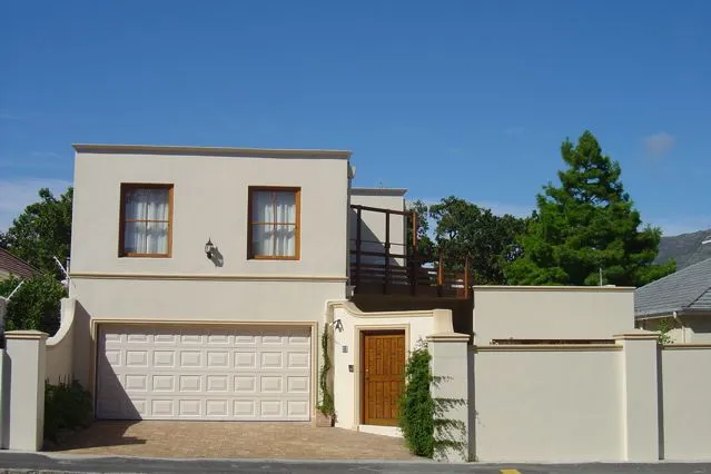 Modern twostory house with garage wooden door and surrounding greenery