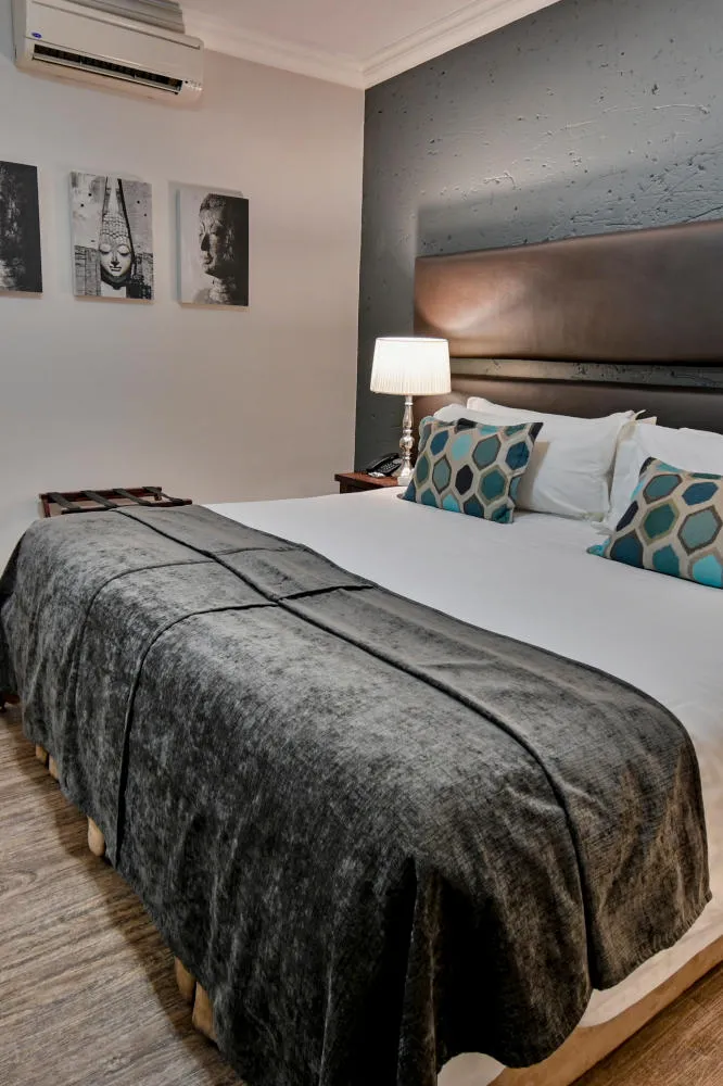 Modern bedroom with a large bed pillows and framed photos on the wall