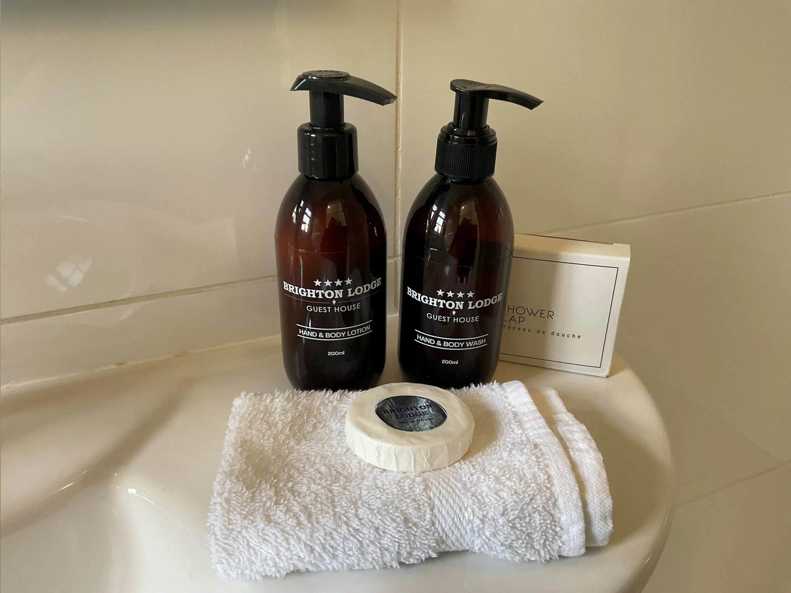 Two soap dispensers a soap towel and a box on a bathroom sink