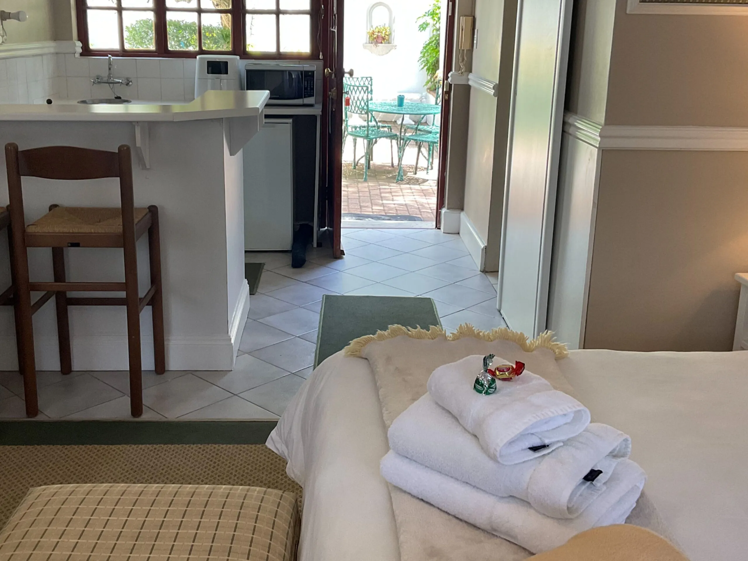 Cozy bedroom with kitchenette and open door to outdoor seating area