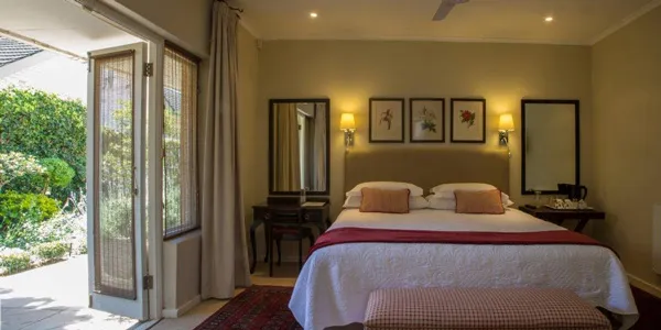 Cozy bedroom with a large bed open patio doors and garden view