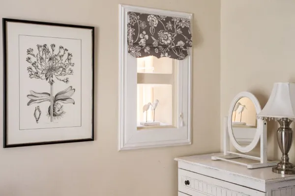 Framed flower print above window with birds mirror and lamp on dresser