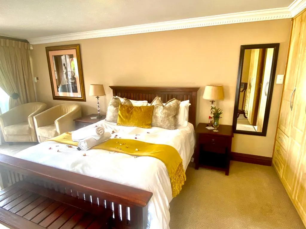 Cozy bedroom with a large bed yellow throw and bedside tables with lamps