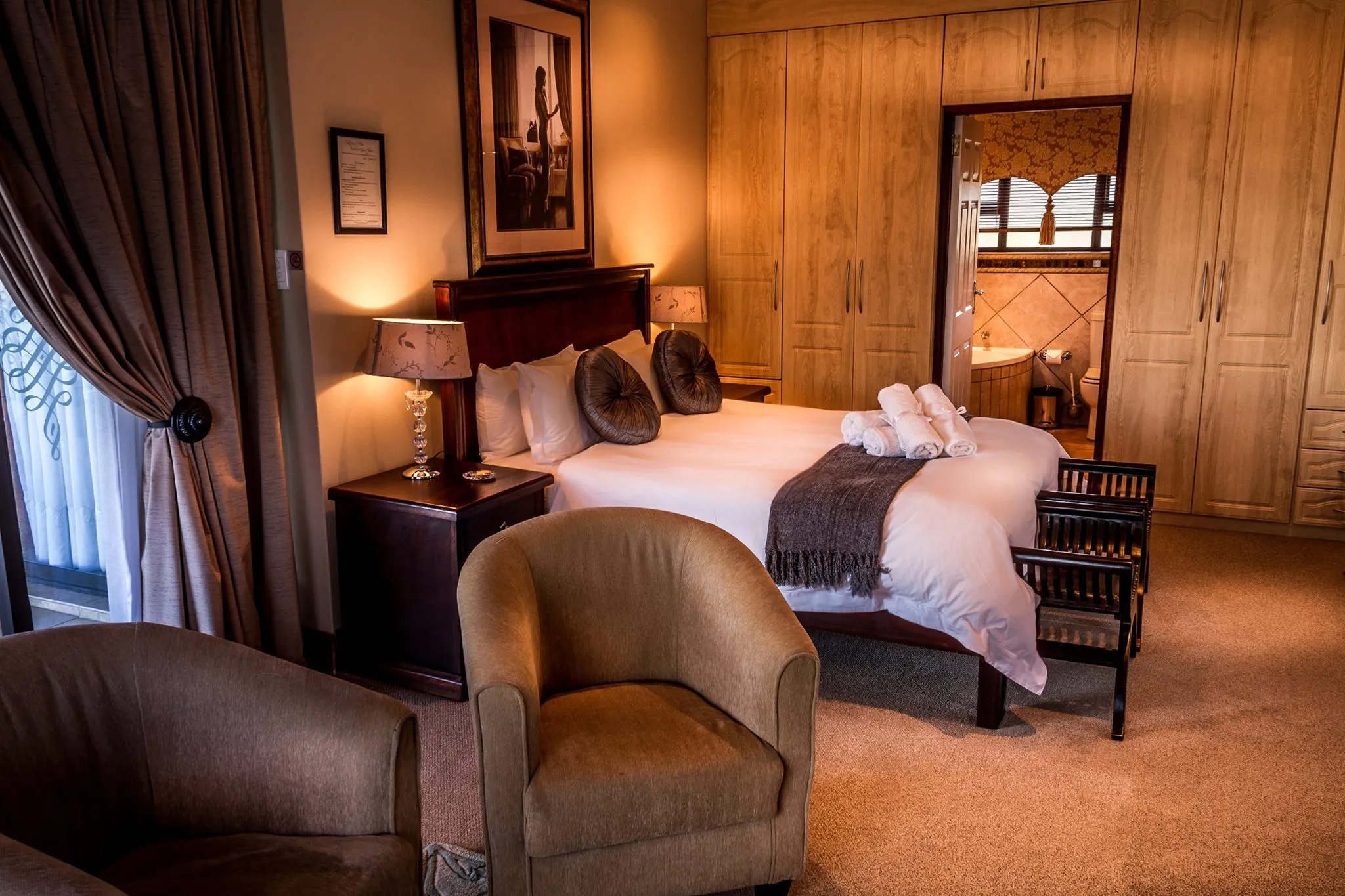 Cozy bedroom with large bed wooden furniture and warm lighting