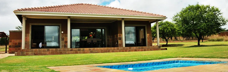 Modern house with large windows green lawn and small swimming pool in front